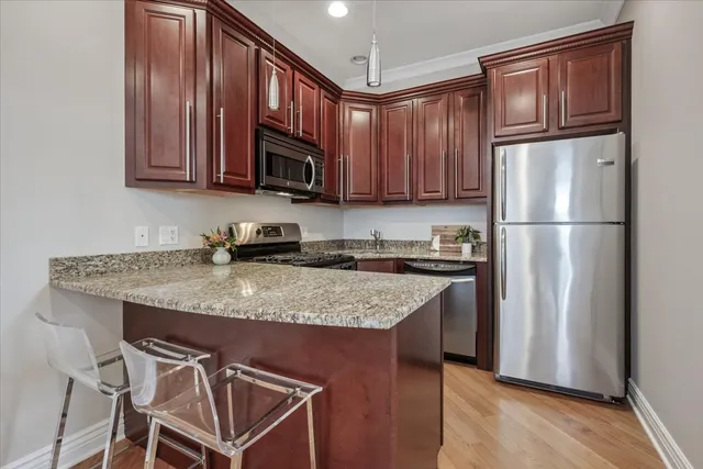 a kitchen with stainless steel appliances granite countertop a refrigerator stove microwave and sink