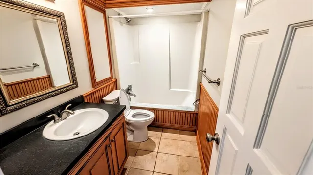 a bathroom with a sink a toilet a mirror and shower