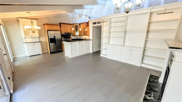 a kitchen with granite countertop a refrigerator and microwave