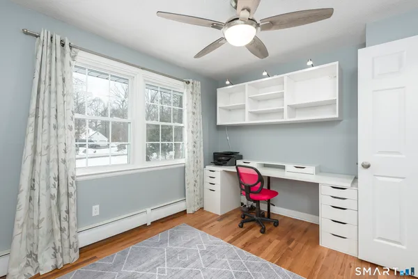 a living room with furniture a flat screen tv and a window