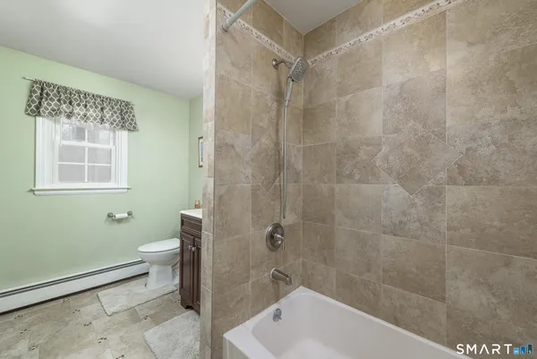 a bath room with a toilet a sink and a bath tub