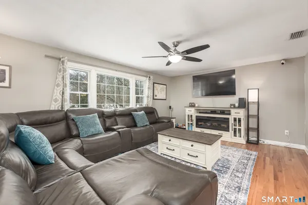 a living room with furniture a fireplace and a flat screen tv