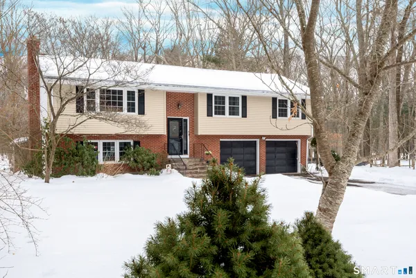 a front view of a house with a yard covered in snow