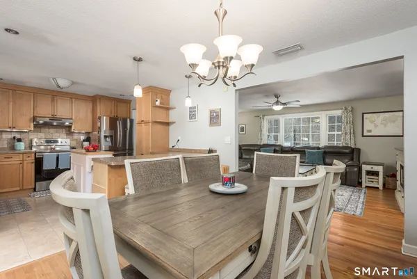a view of a dining room with furniture a chandelier and wooden floor