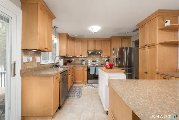 a kitchen with kitchen island a counter top space a sink a refrigerator and cabinets
