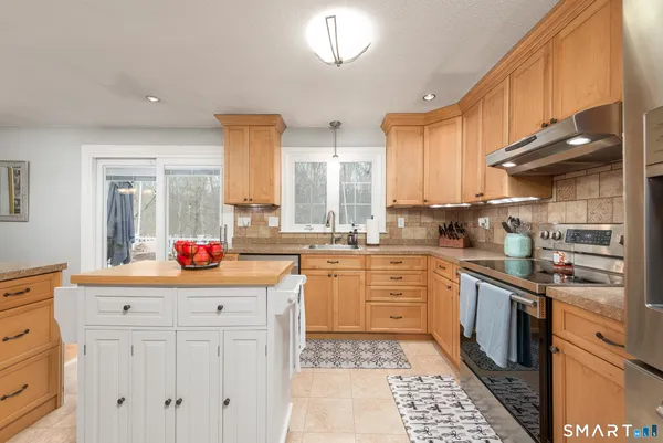 a kitchen with granite countertop white cabinets and white appliances