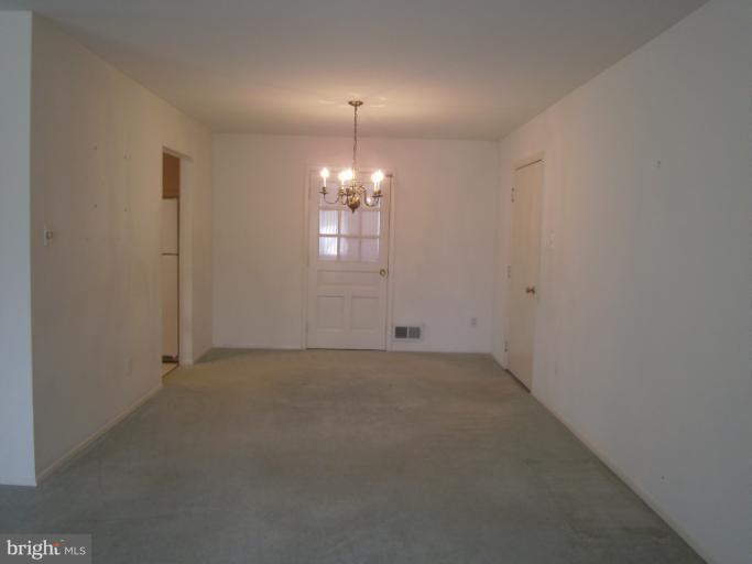 7620 Webbwood Court Springfield, VA 22151 - Photo 3 of 18 en empty room with windows and chandelier fan