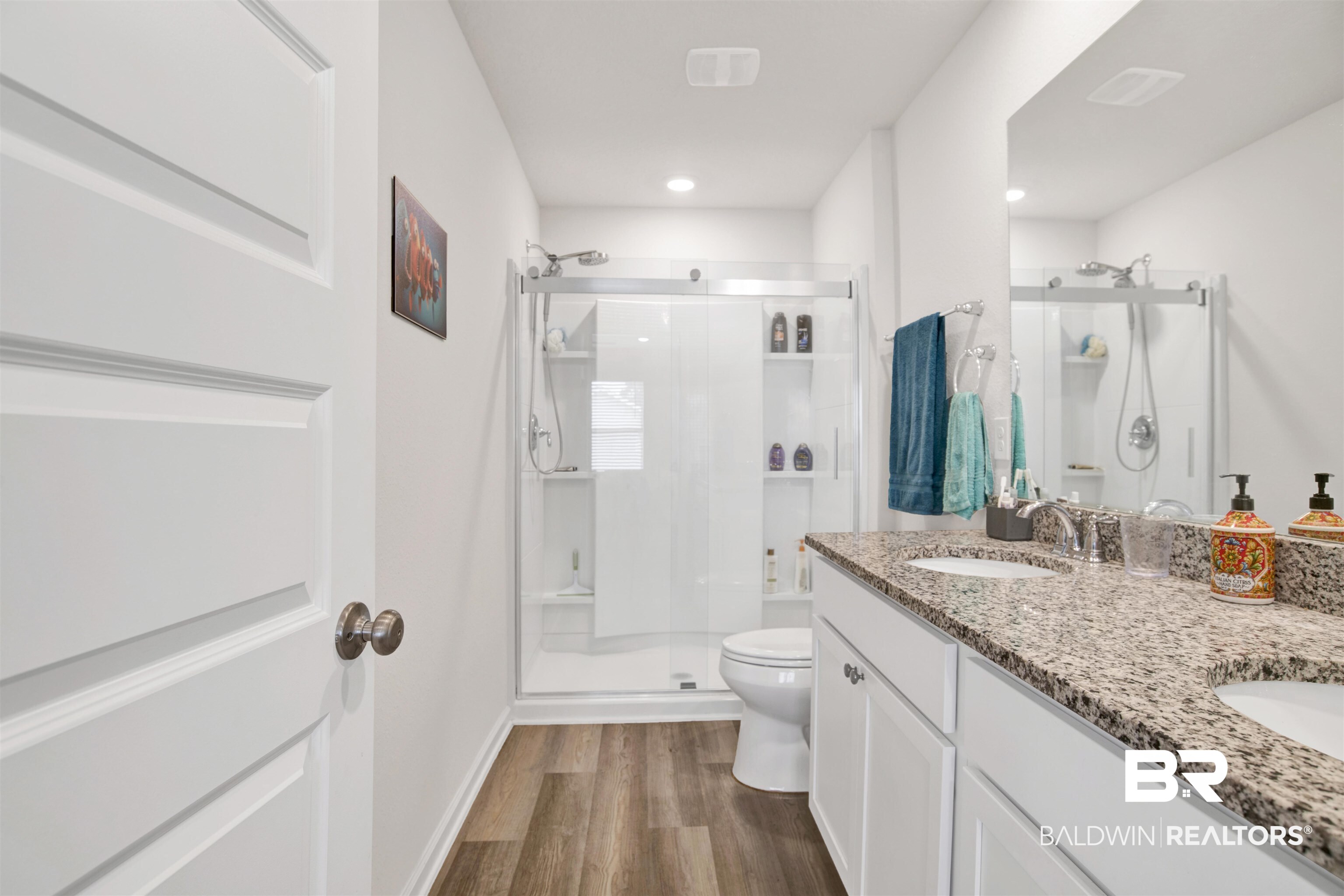 22348 Aleutian Avenue Foley, AL 36535 - Photo 17 of 32 Full bathroom with a shower stall, double vanity, and dark wood-style floors