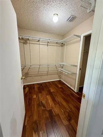 a view of walk in closet with wooden floor