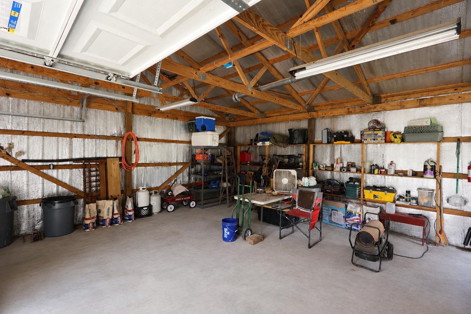 3226 19th Highway West Ripley, TN 38063 - Photo 3 of 18 Spacious workshop featuring exposed wooden beam construction with high ceilings, concrete flooring, and ample natural light from skylights and clerestory windows