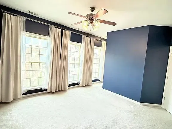 an empty room with windows and closet