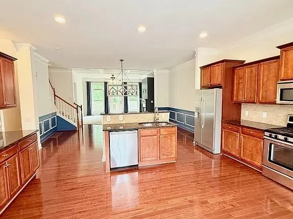 a large kitchen with stainless steel appliances wooden floors and wooden cabinets