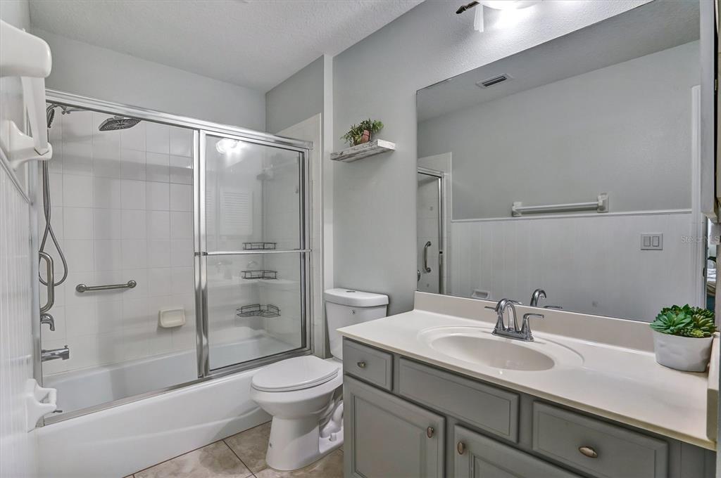5010 Treasure Cay Road Tavares, FL 32778 - Photo 16 of 32 a bathroom with a shower sink vanity mirror and toilet