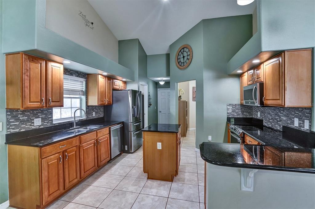 5010 Treasure Cay Road Tavares, FL 32778 - Photo 4 of 32 a kitchen with stainless steel appliances granite countertop a refrigerator and a stove