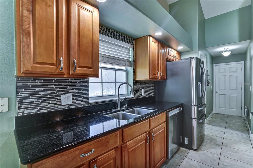 5010 Treasure Cay Road Tavares, FL 32778 - Photo 5 of 32 a kitchen with granite countertop a sink stainless steel appliances and cabinets