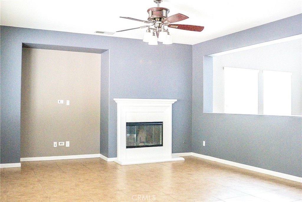 1373 Aztec Court Beaumont, CA 92223 - Photo 15 of 56 a view of an empty room with chandelier fan and a fireplace