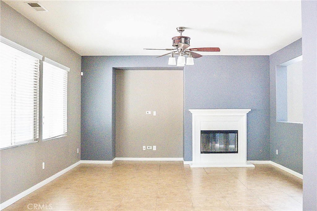 1373 Aztec Court Beaumont, CA 92223 - Photo 16 of 56 a view of an empty room with a fireplace and a window