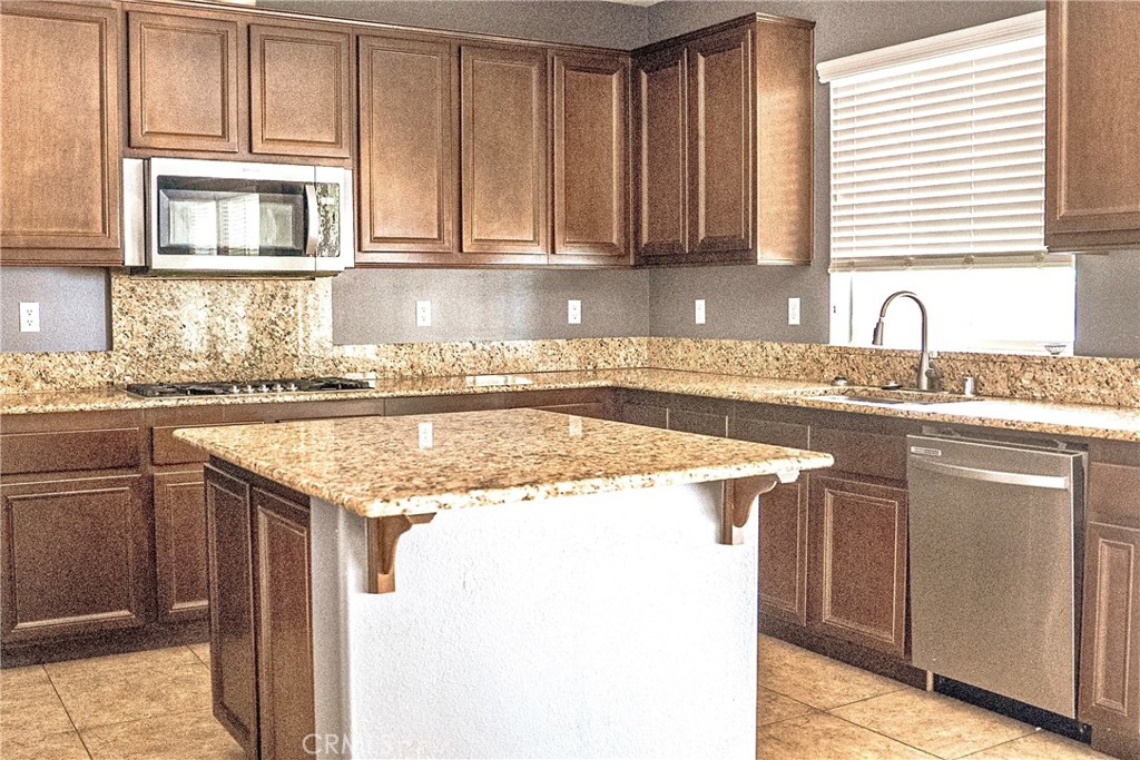 1373 Aztec Court Beaumont, CA 92223 - Photo 17 of 56 a kitchen with granite countertop a sink and a stove
