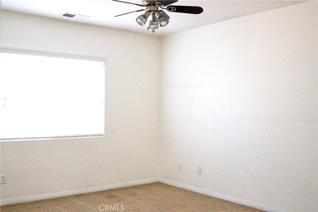 1373 Aztec Court Beaumont, CA 92223 - Photo 40 of 56 a room with a window and a ceiling fan