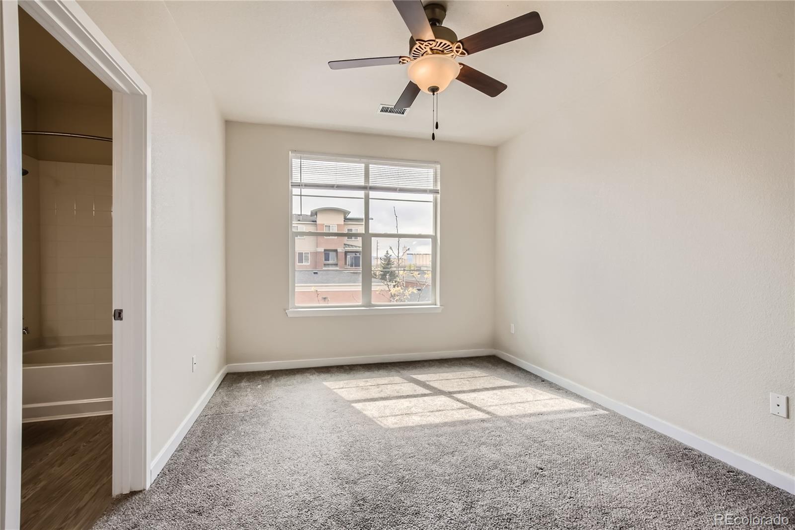 4100 Albion Street, Unit 514 Denver, CO 80216 - Photo 11 of 31 an empty room with windows and fan
