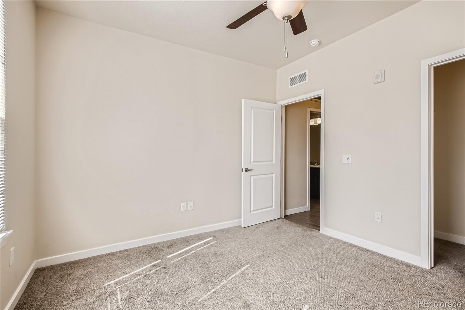 4100 Albion Street, Unit 514 Denver, CO 80216 - Photo 16 of 31 an empty room with a ceiling fan and a window