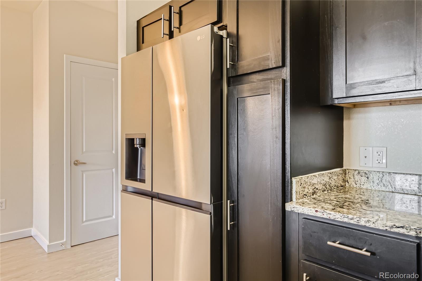 4100 Albion Street, Unit 514 Denver, CO 80216 - Photo 9 of 31 a view of a kitchen with a refrigerator and cabinets