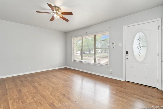 wooden floor in an empty room with a window