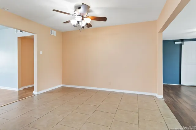 an empty room with closet and a chandelier fan