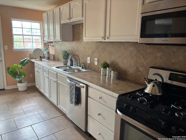 a kitchen with a sink stove and cabinets