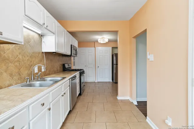 a kitchen with granite countertop a sink and cabinets