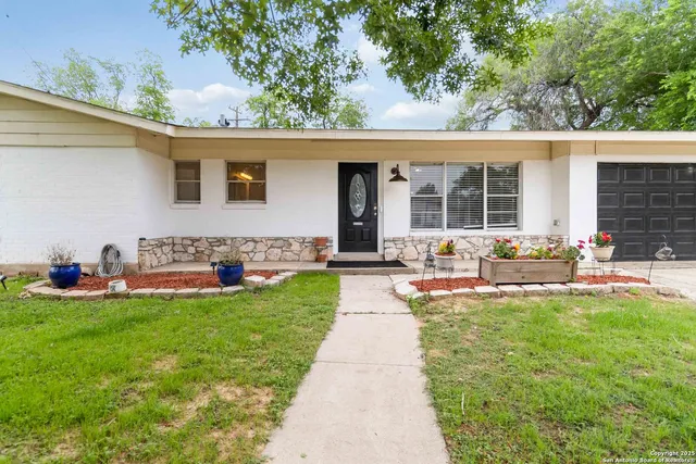 a front view of a house with patio and a garden