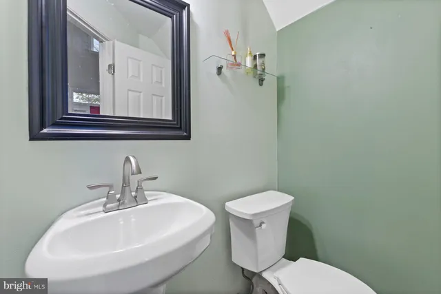 a bathroom with a toilet a sink and mirror