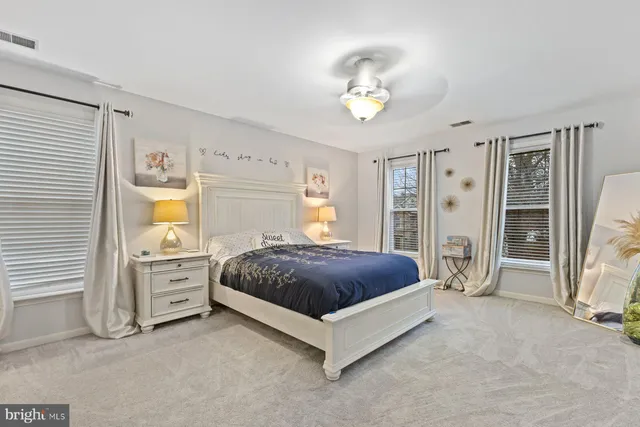 a spacious bedroom with a large bed and a chandelier