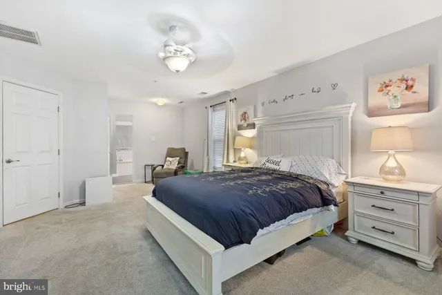 a spacious bedroom with a bed and a chandelier