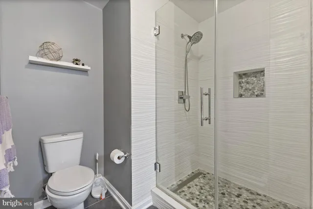 a white toilet sitting next to a bathroom