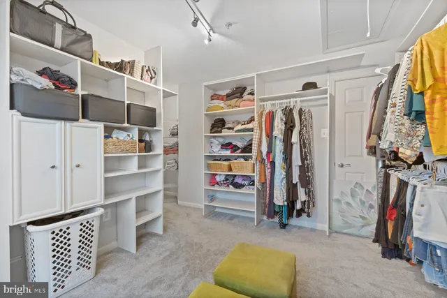 a view of walk in closet with clothes and shoes