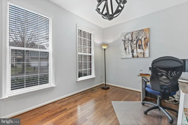 a view of a workspace with furniture and a window
