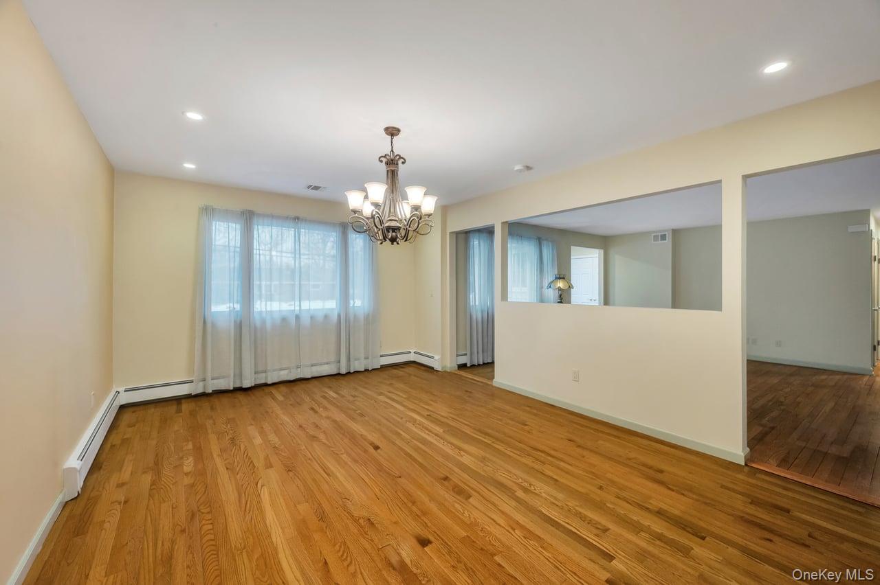 105 Browns Road Nesconset, NY 11767 - Photo 19 of 50 a view of an empty room with wooden floor and kitchen view