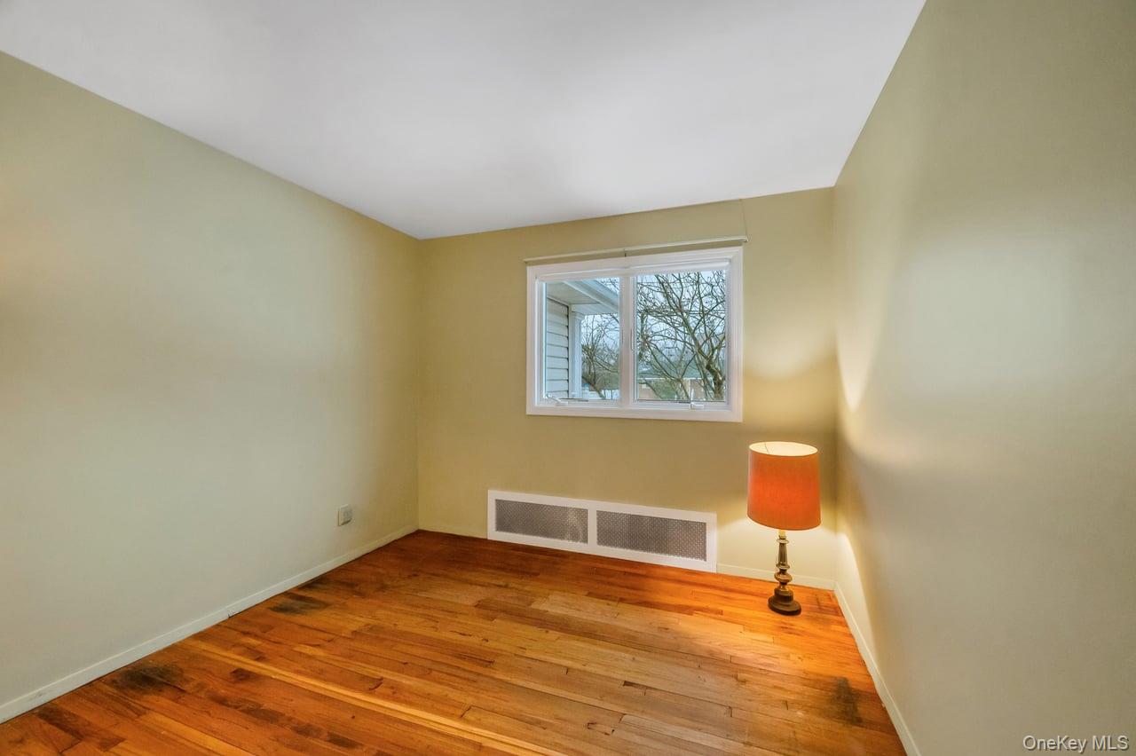 105 Browns Road Nesconset, NY 11767 - Photo 30 of 50 a bedroom with a bed and a lamp on the table