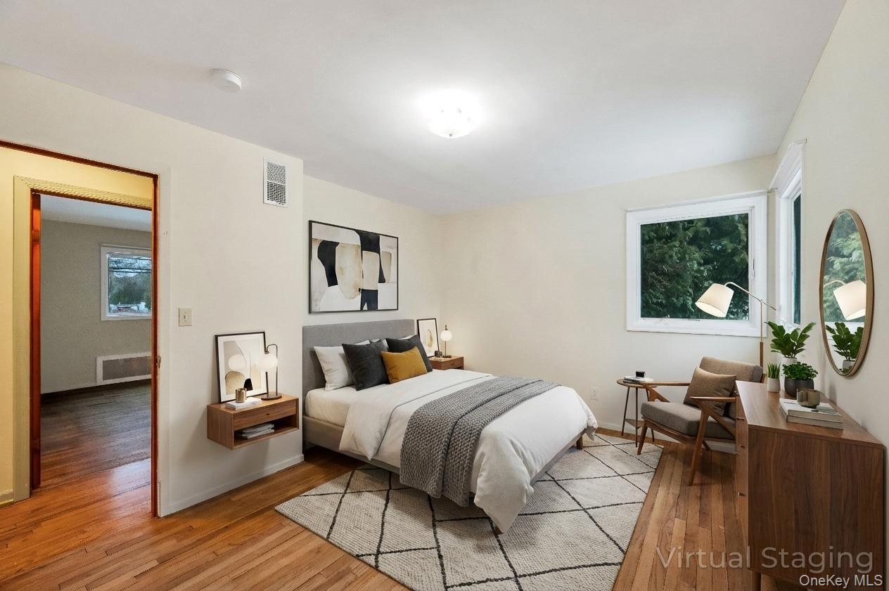 105 Browns Road Nesconset, NY 11767 - Photo 32 of 50 a bedroom with a bed wooden floor and windows