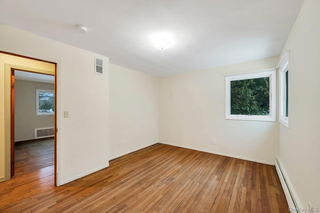 105 Browns Road Nesconset, NY 11767 - Photo 33 of 50 an empty room with wooden floor and windows