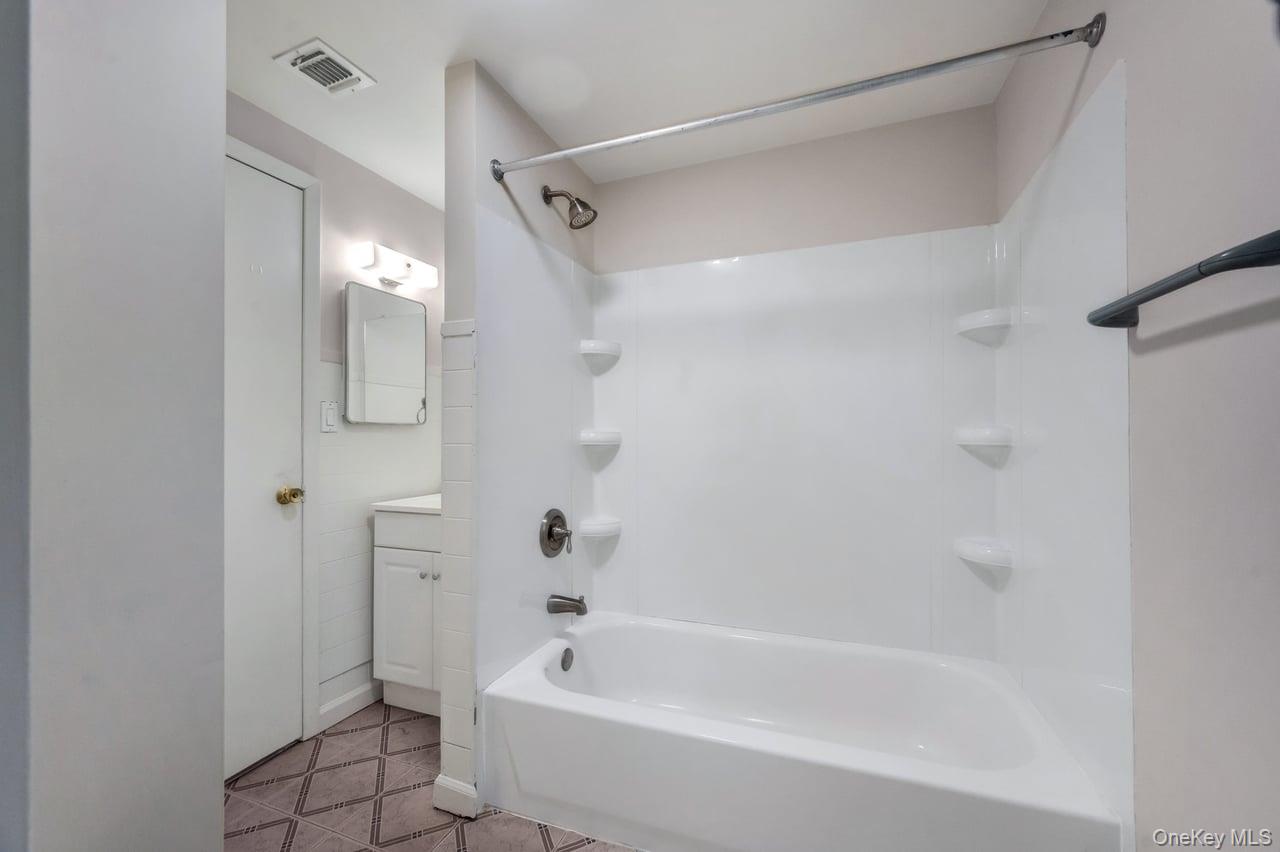 105 Browns Road Nesconset, NY 11767 - Photo 44 of 50 a bathroom with a bathtub and a shower