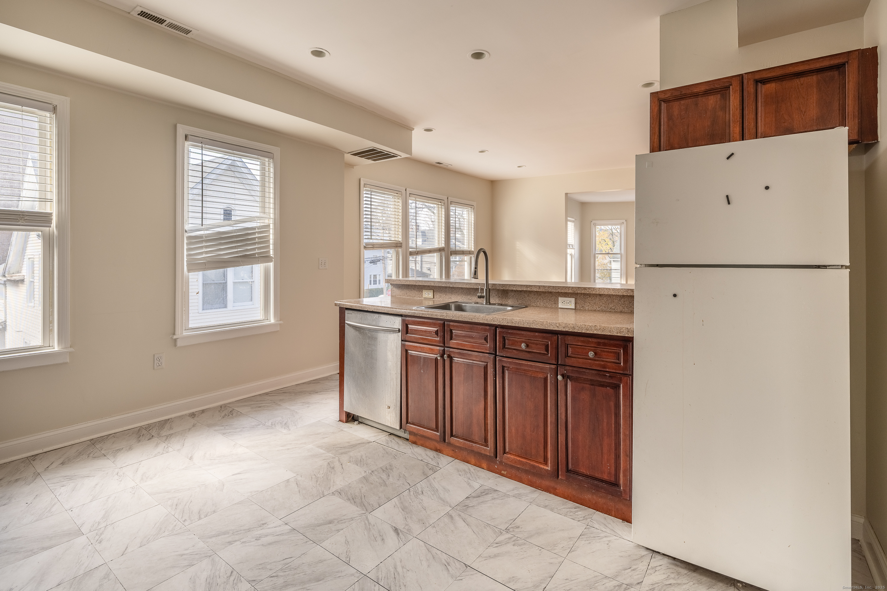 25 Hunting Street Bridgeport, CT 06606 - Photo 16 of 26 a kitchen with stainless steel appliances granite countertop a refrigerator a sink a stove a dining table and chairs