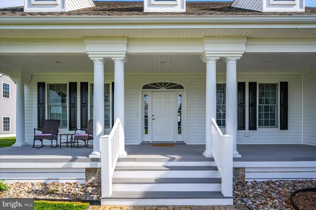 a front view of a house with swimming pool and garden