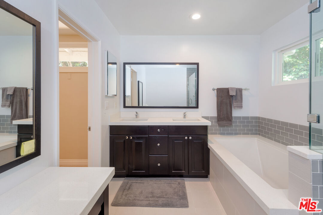 3632 Valley Meadow Road Sherman Oaks, CA 91403 - Photo 11 of 18 a spacious bathroom with a tub sink and mirror