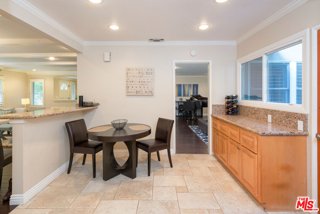 3632 Valley Meadow Road Sherman Oaks, CA 91403 - Photo 7 of 18 a kitchen with stainless steel appliances granite countertop a sink a stove a dining table and chairs