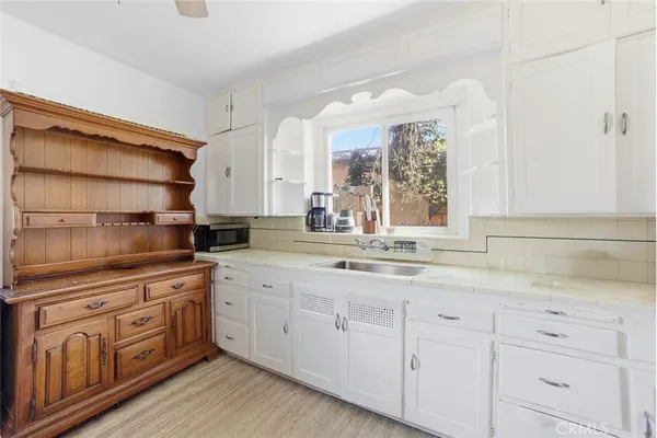 a kitchen with white cabinets and white appliances