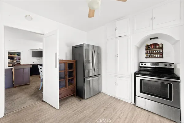 a kitchen with stainless steel appliances a stove a refrigerator a sink a oven with wooden floor