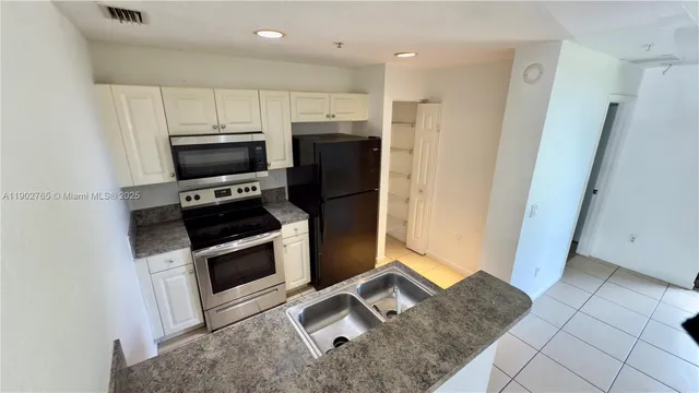a kitchen with a sink stainless steel appliances and cabinets
