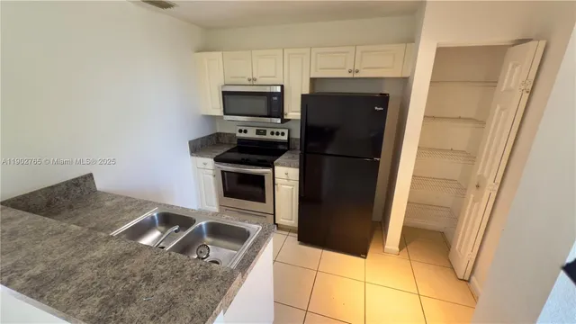 a kitchen with stainless steel appliances granite countertop a refrigerator stove and sink